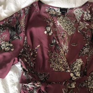 Purple v-neck blouse with floral pattern.